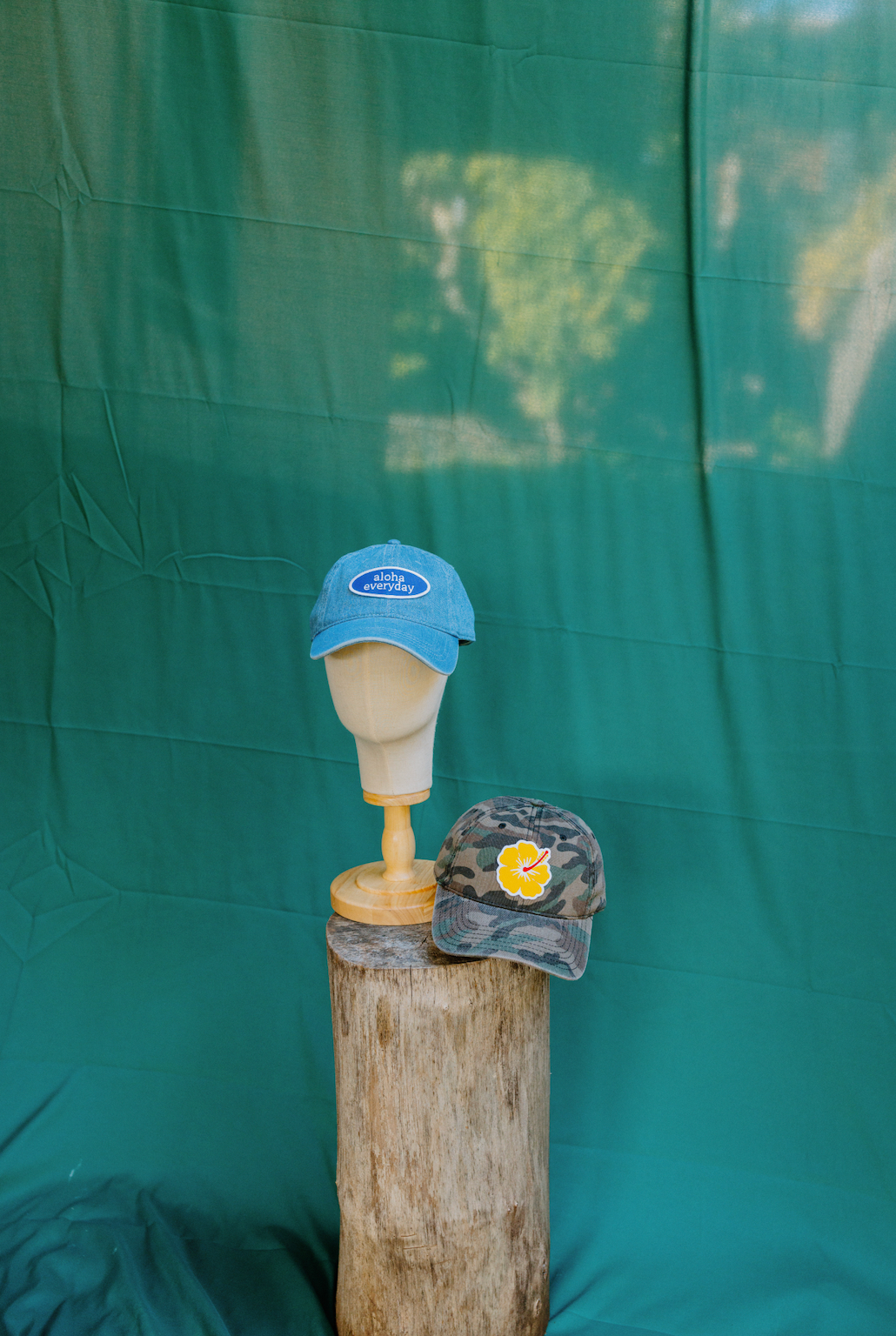 "Custom dark green camouflage baseball cap with yellow hibiscus patch, adjustable back strap, made from 100% cotton."