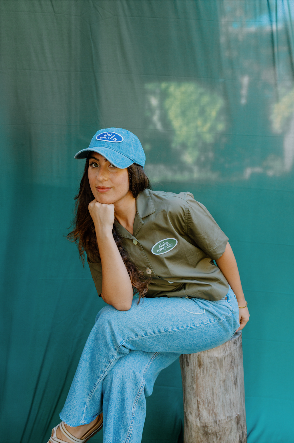 “Model wearing upcycled women’s button-up shirt with ‘Aloha Everyday’ vintage patch, styled with denim and a casual, relaxed fit.”