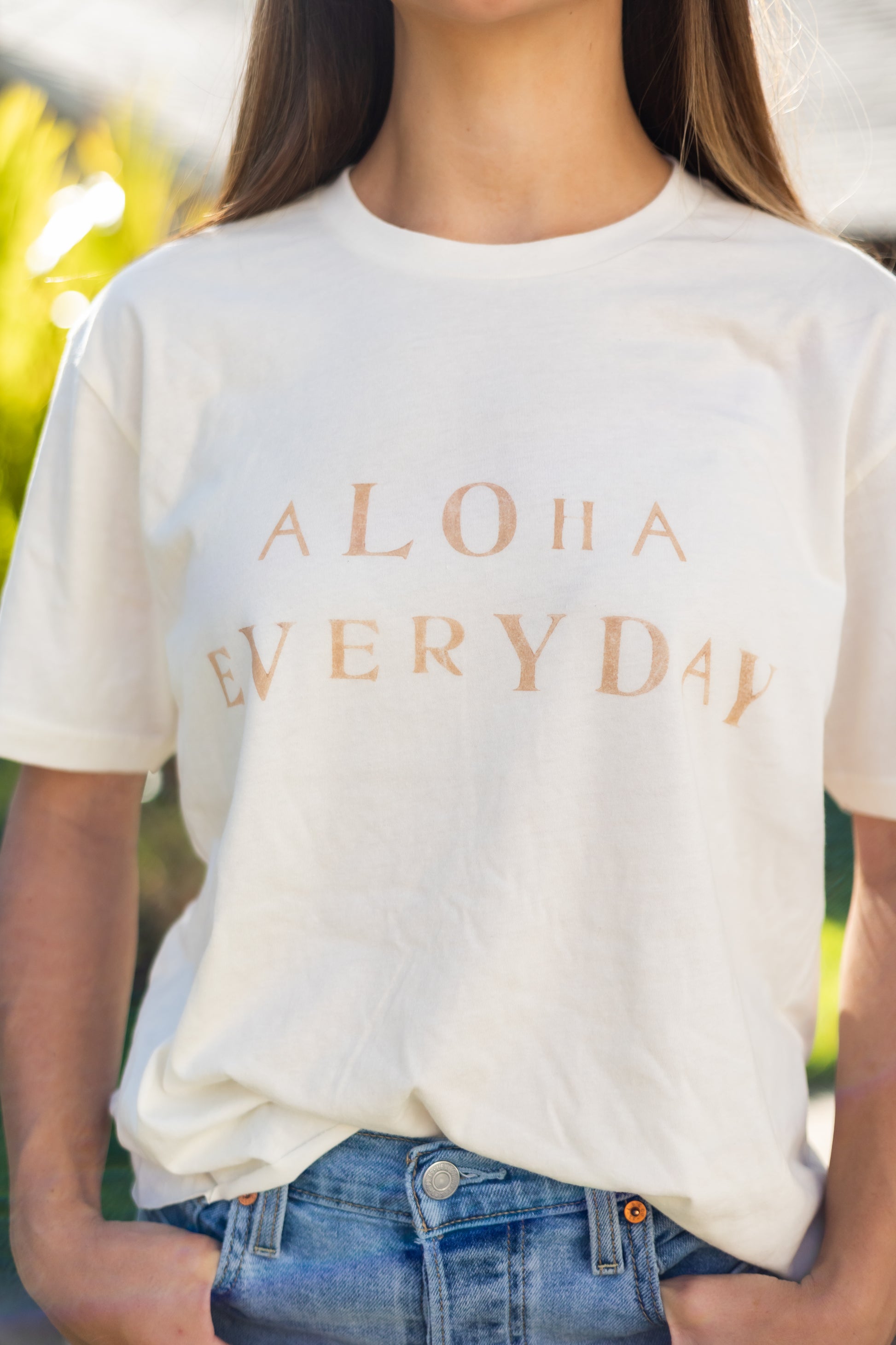 Can you really ever have enough comfy tees? We don't think so. Our white tees are made with organic cotton. Featuring a hand stamped lettering unique to each tee. This shirt is completely plant based and safe on your skin and our planet. This tee comes pre-cut at the hem for the perfect length, hitting right at your waistline. Pre-washed for ultimate comfort and added softness.  Hand Stamped  Perfect for high-waisted bottoms, can be tucked in  Raw Hemline, Relaxed Fit  Model is wearing size medium